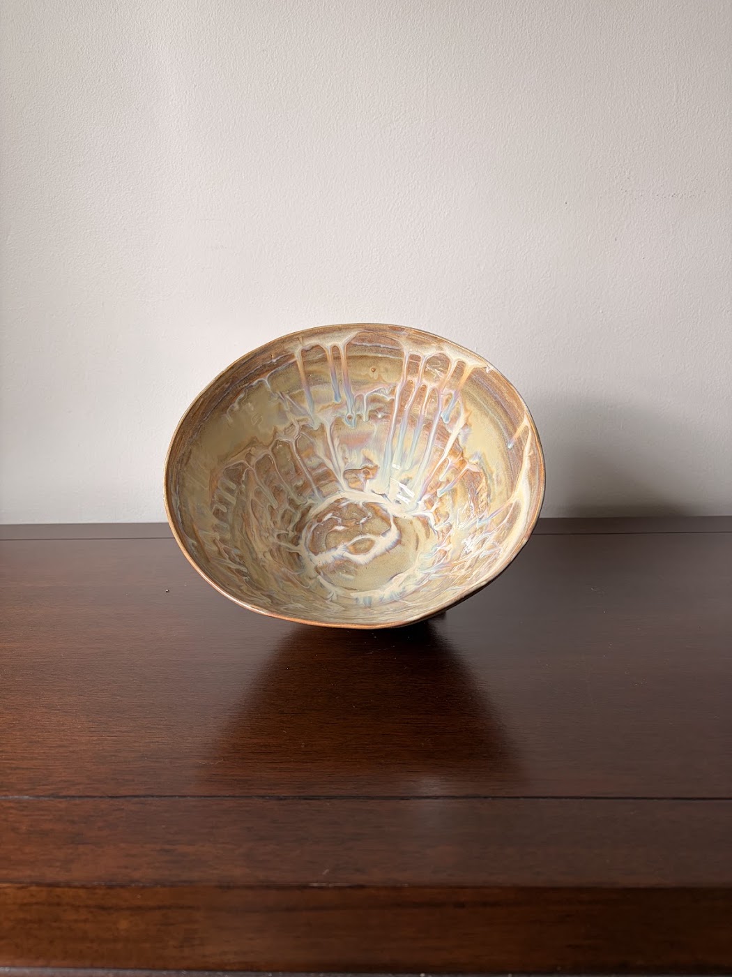Wide ceramic bowl with iron luster drips and warm glaze