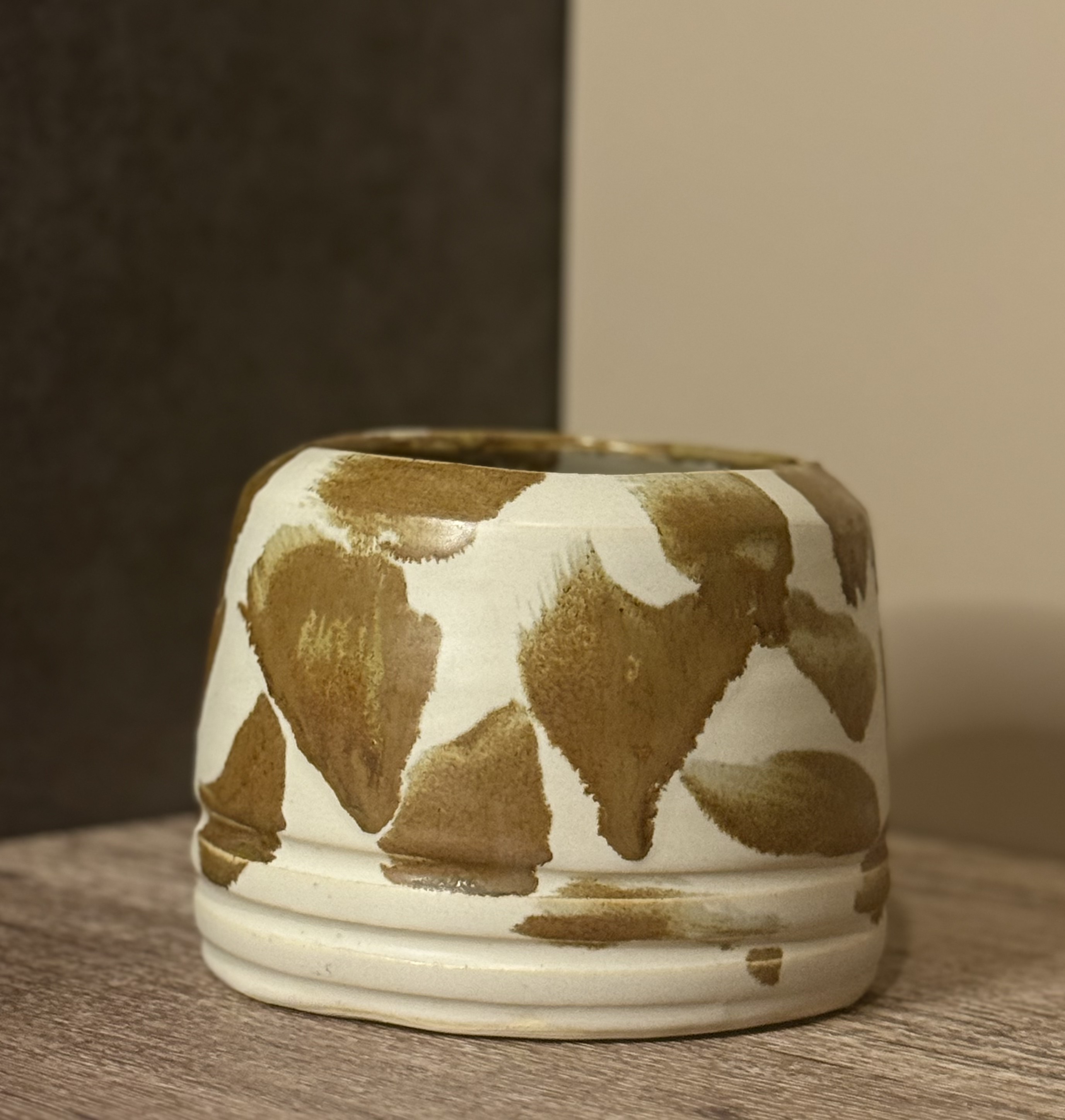 Rounded ceramic planter with loose amber brushstrokes on white